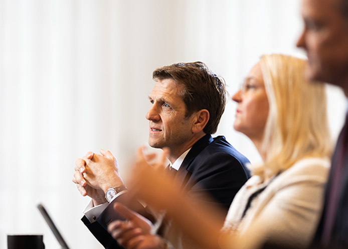Three people dressed smartly, engaged in a business meeting.