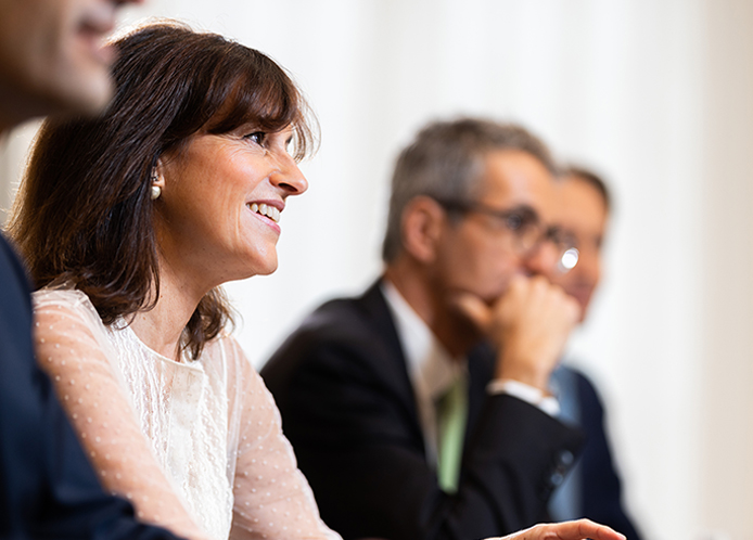Four smartly dressed people at a meeting table in a professional setting